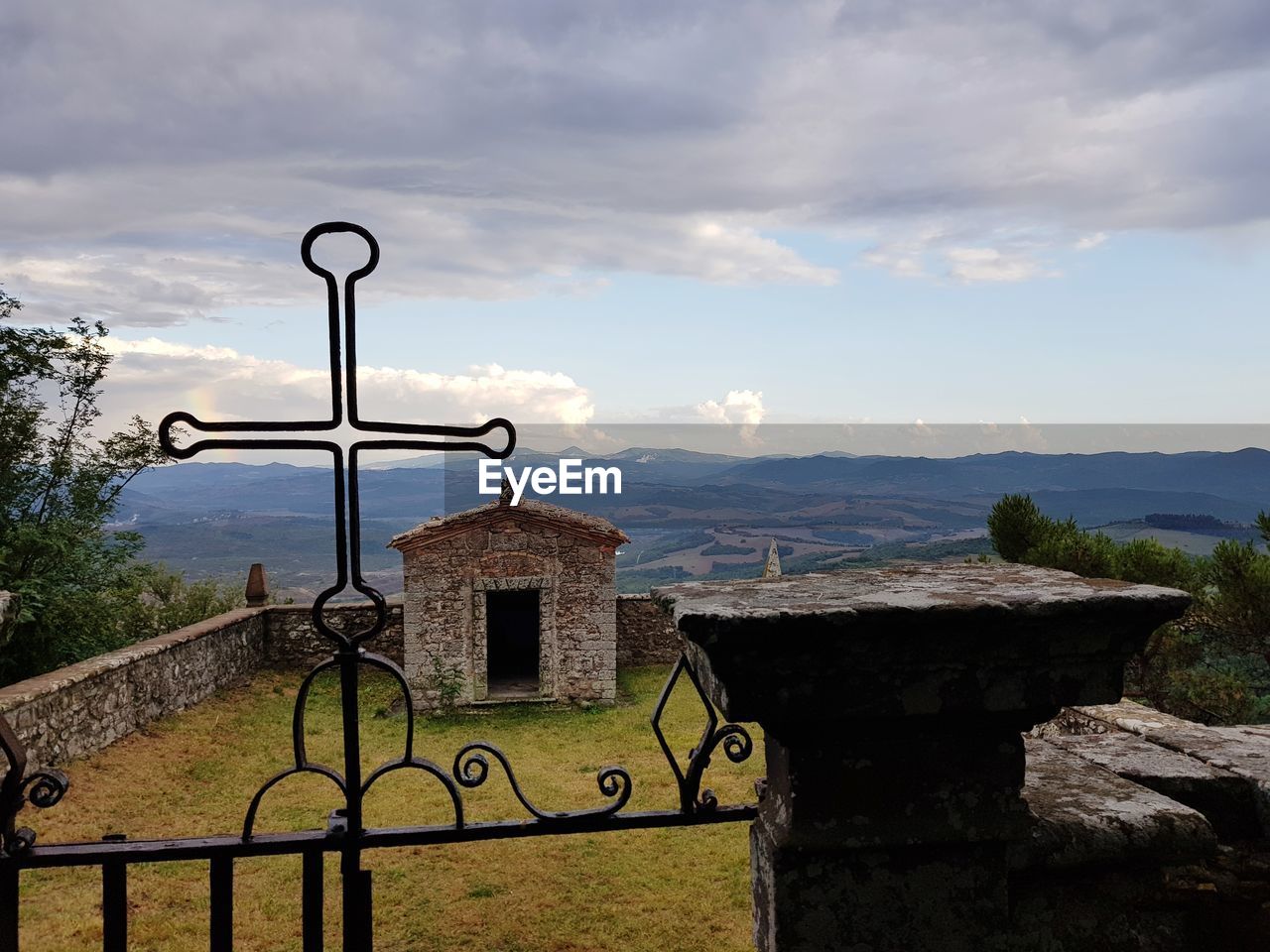 Cross by building against sky