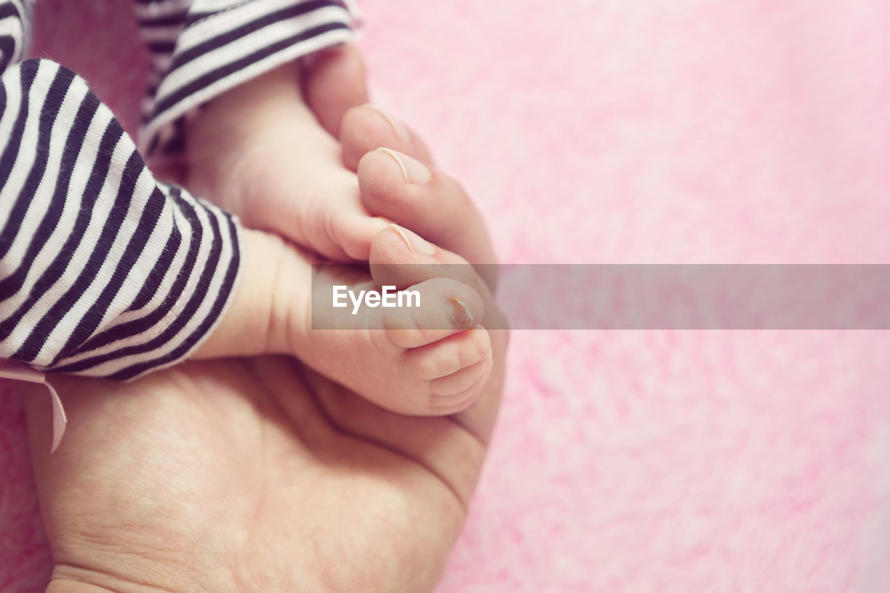 Cropped image of parent and baby girl on rug