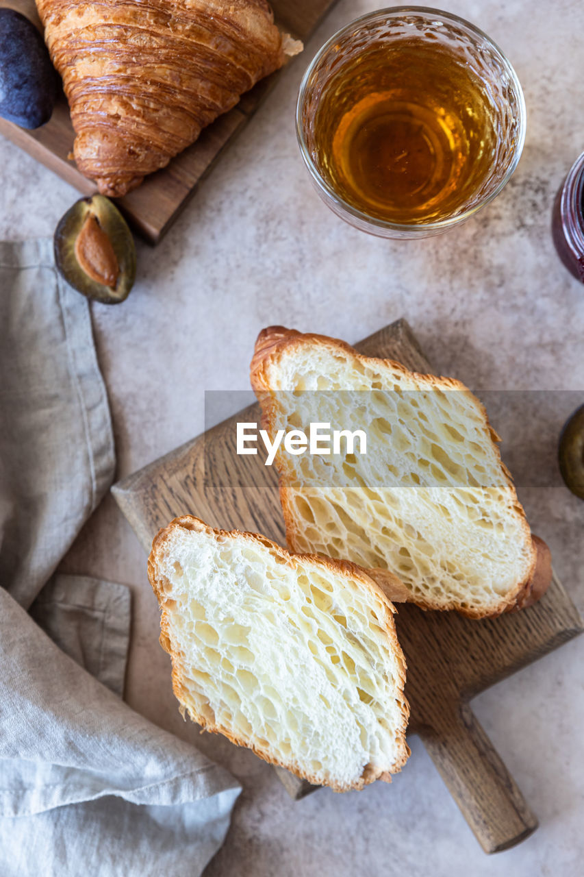 Delicious breakfast with fresh croissants, plum jam and juice