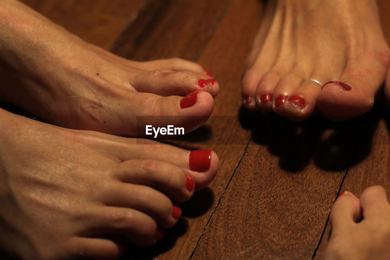 Low section of women with red nail polish