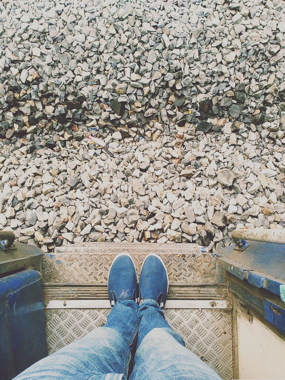 Low section of man standing in train against gravel