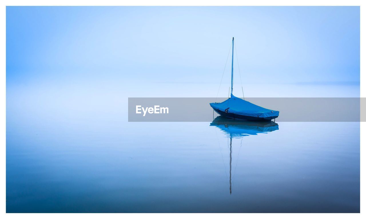 Sailboat moored in sea