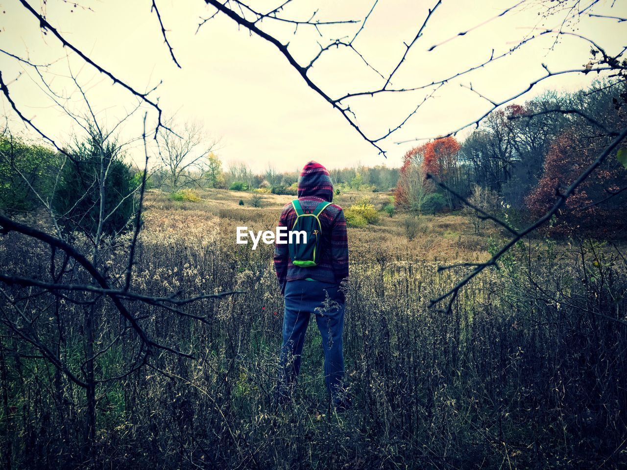 REAR VIEW OF PEOPLE WALKING ON FIELD