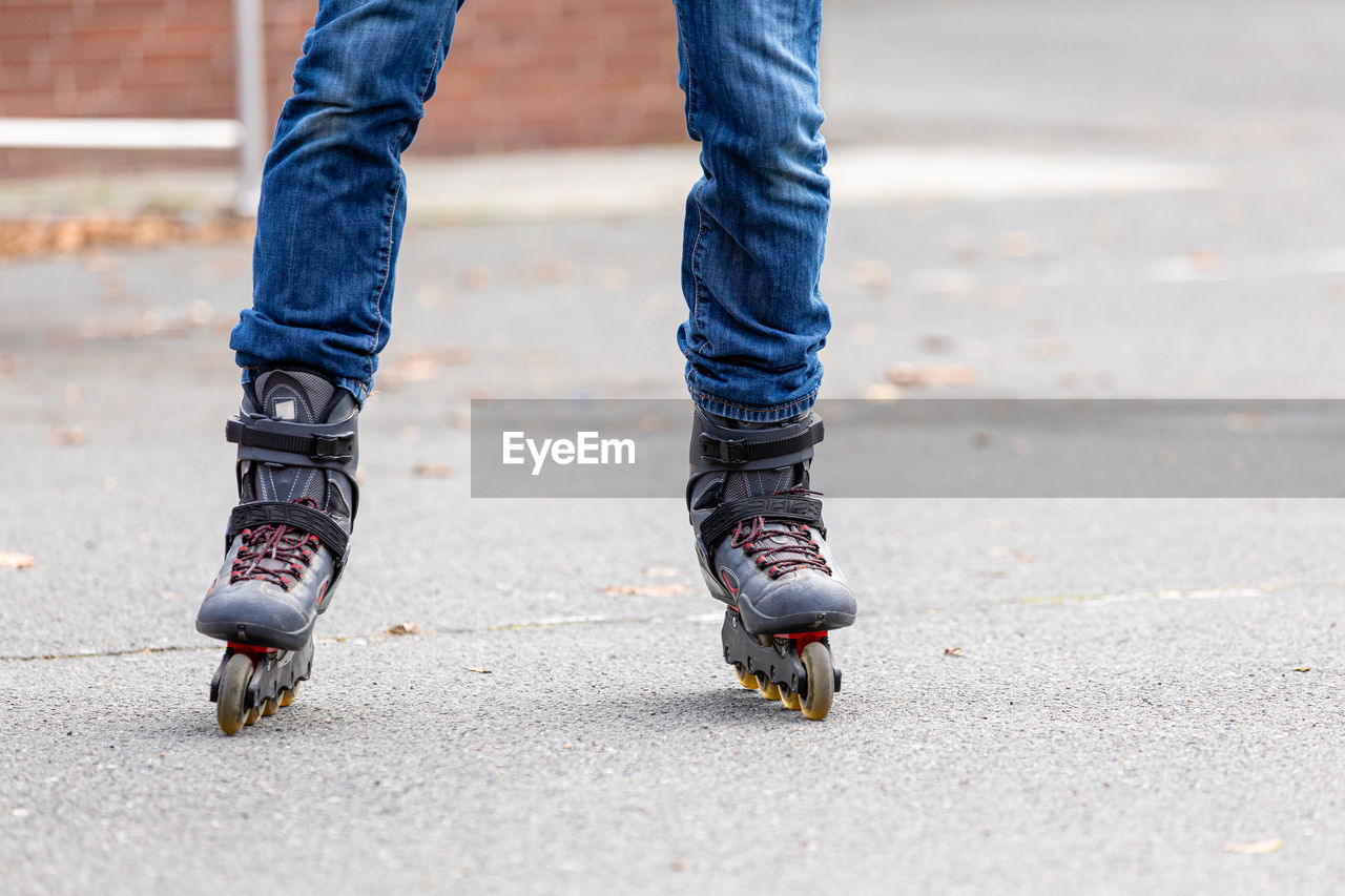 LOW SECTION OF MAN STANDING ON COBBLESTONE STREET