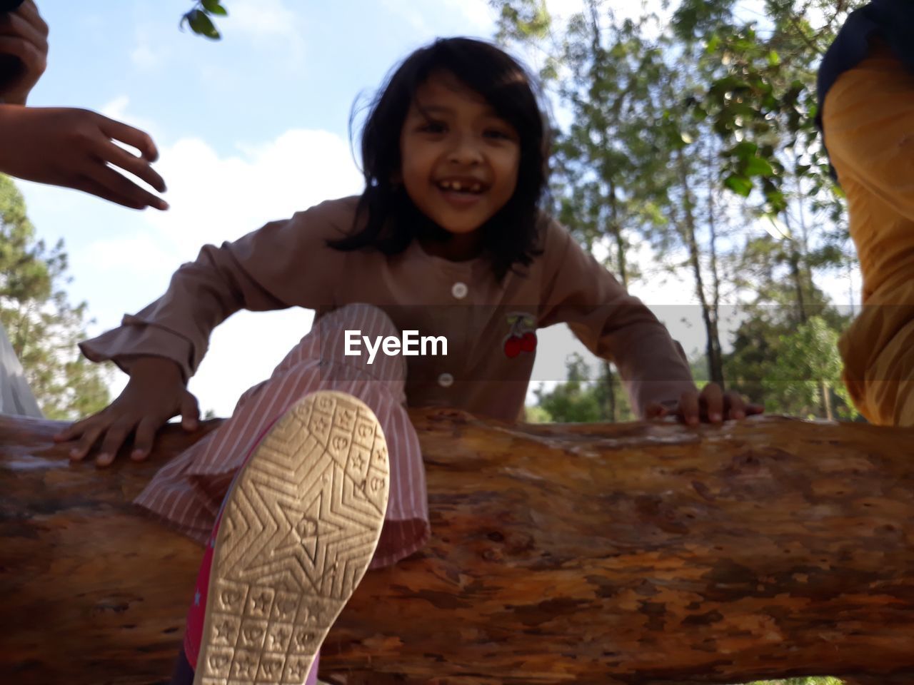 Portrait of smiling girl against trees