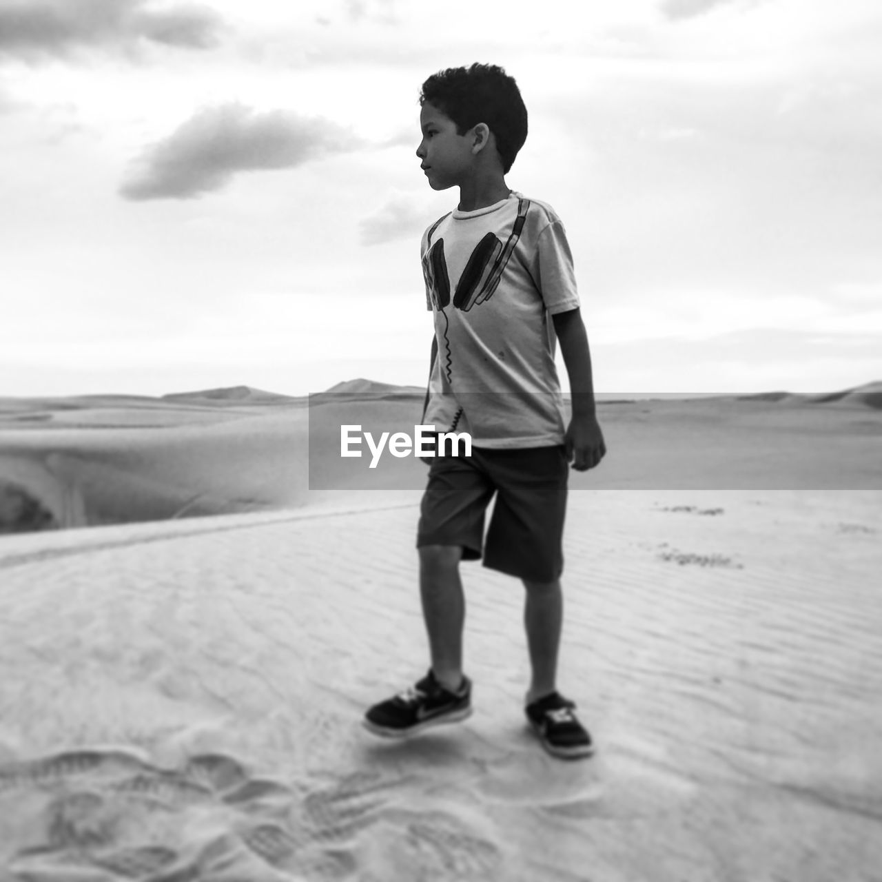 FULL LENGTH OF MAN ON SAND DUNE IN DESERT