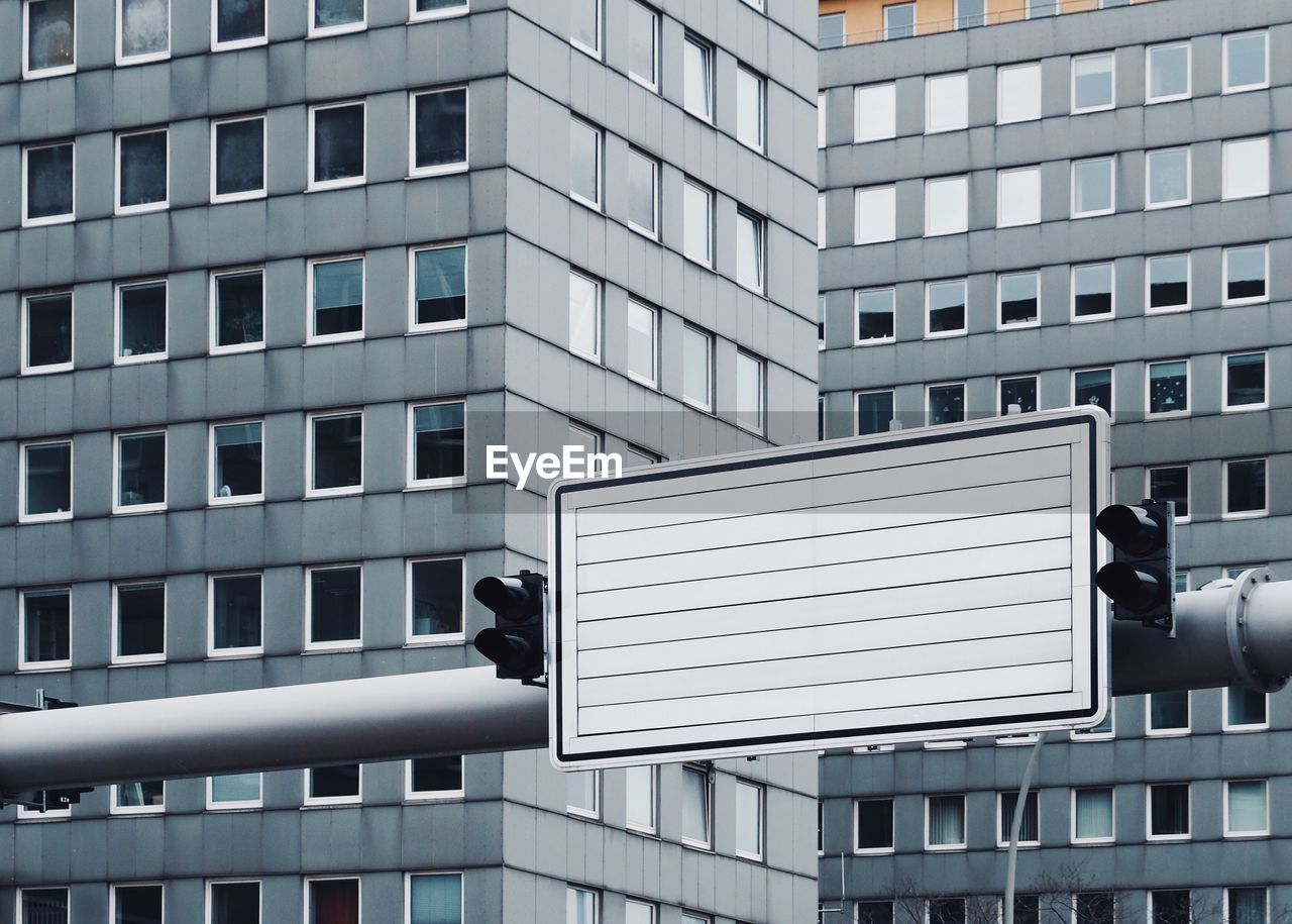 Blank road sign against building