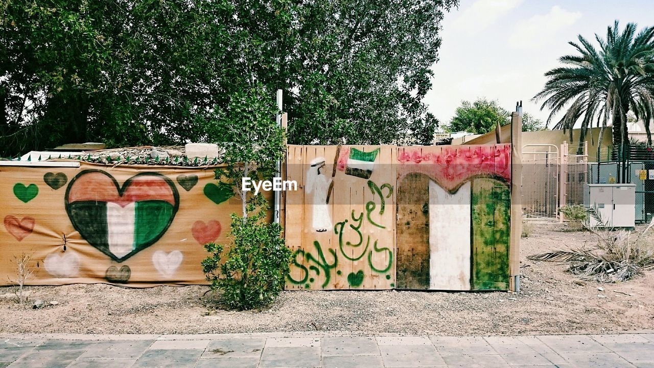 GRAFFITI ON WALL AGAINST PLANTS