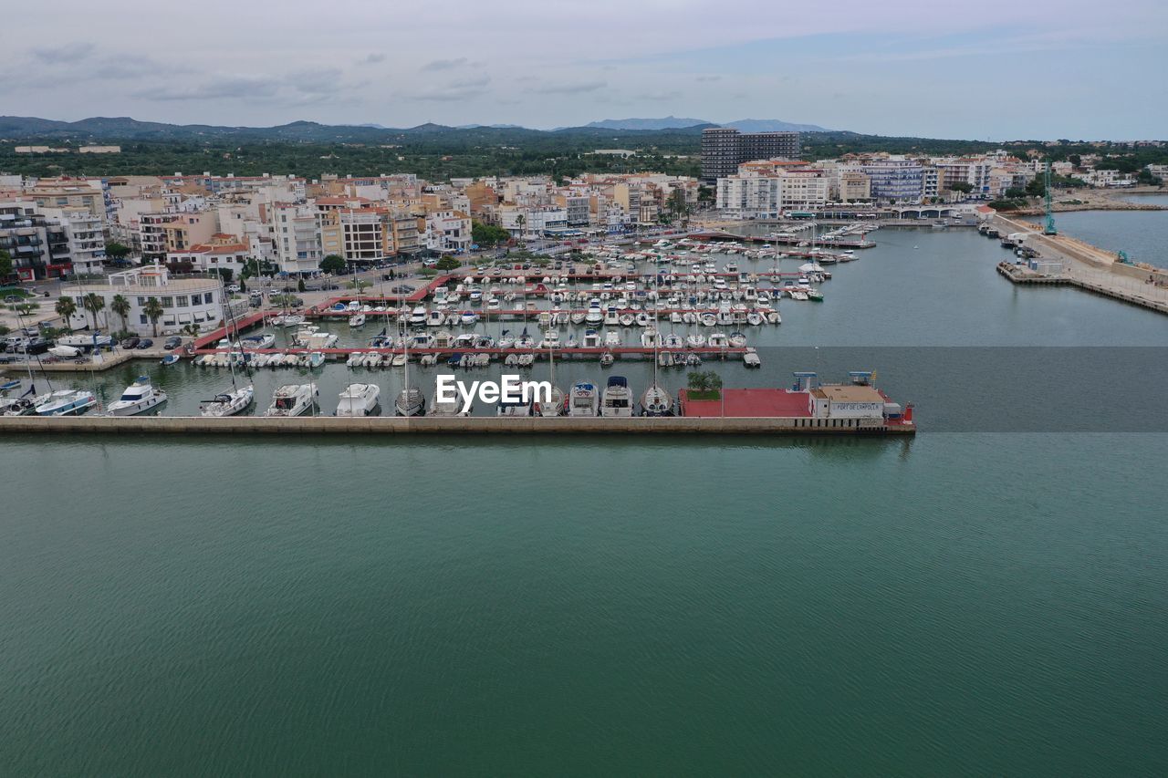 water, architecture, building exterior, sea, nautical vessel, built structure, transportation, city, building, harbor, nature, port, mode of transportation, no people, high angle view, waterfront, pier, vehicle, business, sky, residential district, coast, ship, freight transportation, travel destinations, commercial dock, dock, cityscape, bay, outdoors, industry, travel, day, shipping, trading, marina, house, aerial view, channel, container, aerial photography, land, cargo container, town, watercraft, tourism, beach