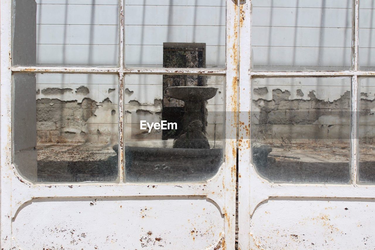 Reflection on glass window of abandoned building