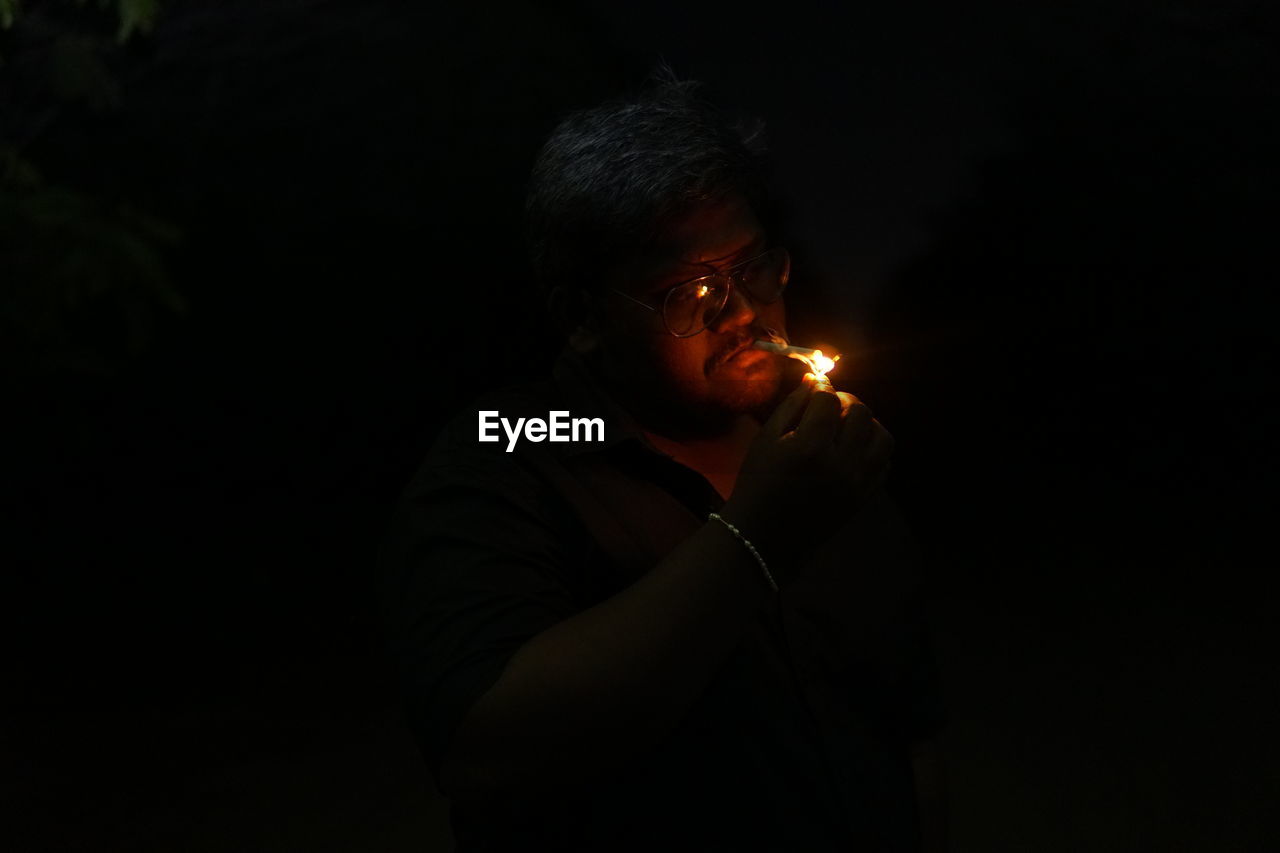 Man igniting cigarette in dark