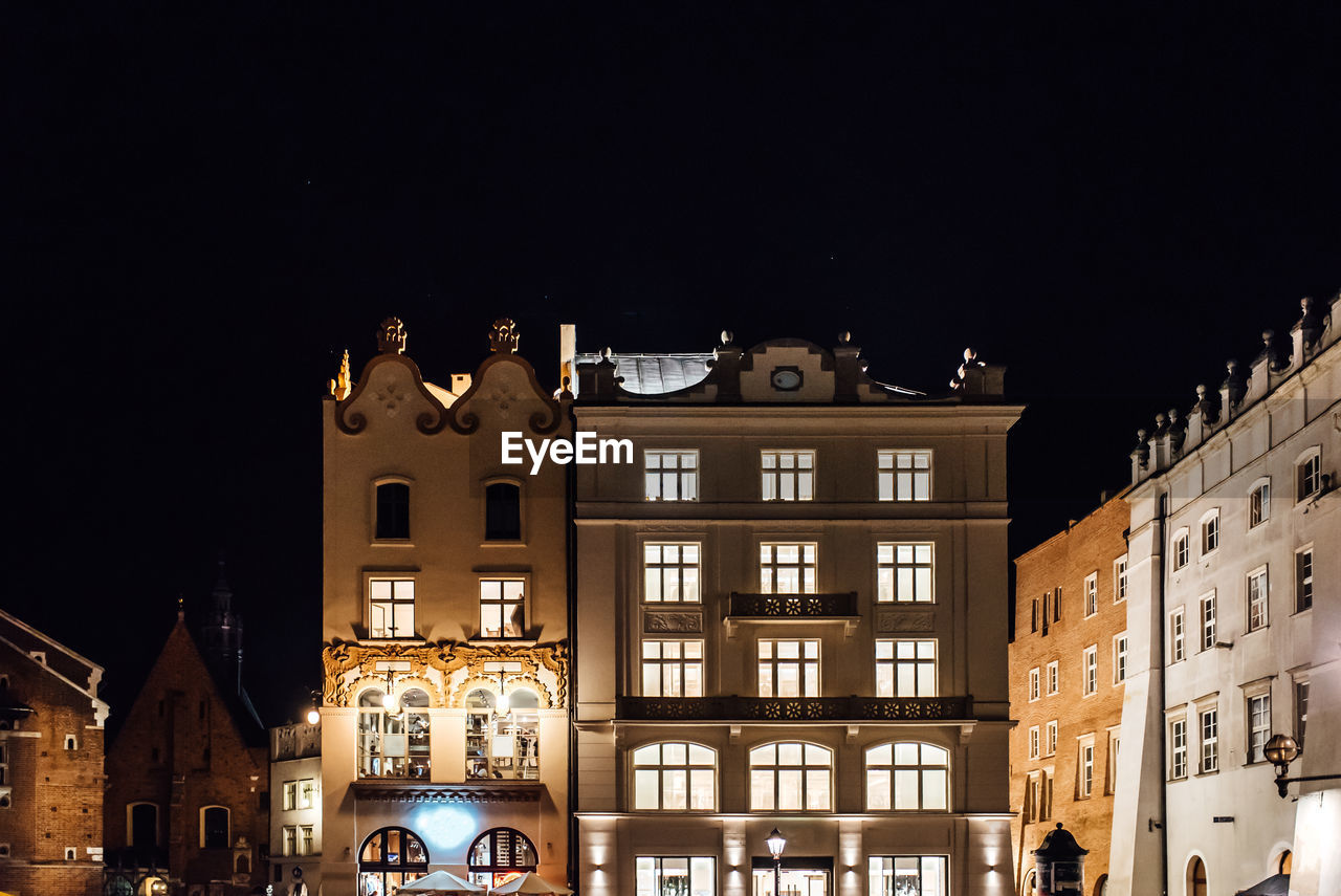 LOW ANGLE VIEW OF BUILDINGS AGAINST SKY AT NIGHT