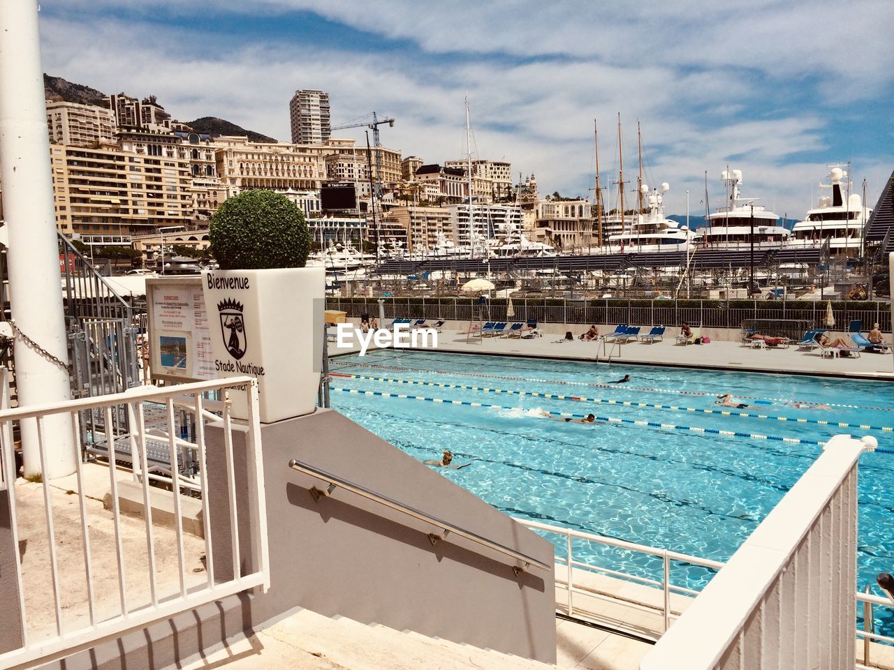 BUILDINGS BY SWIMMING POOL AGAINST SKY