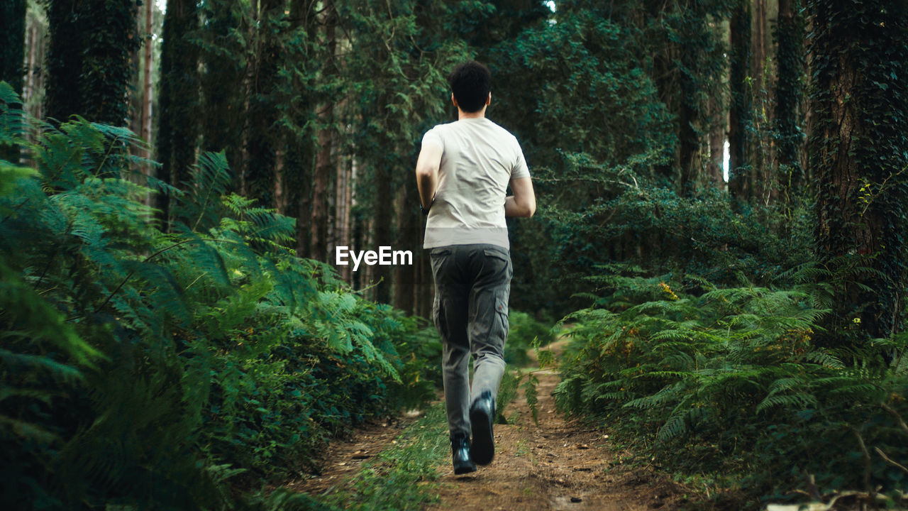 Boy trains by running on a trail in the mountains at night