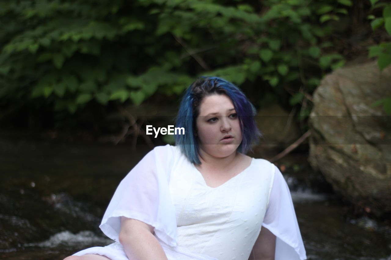 Woman looking away against plants