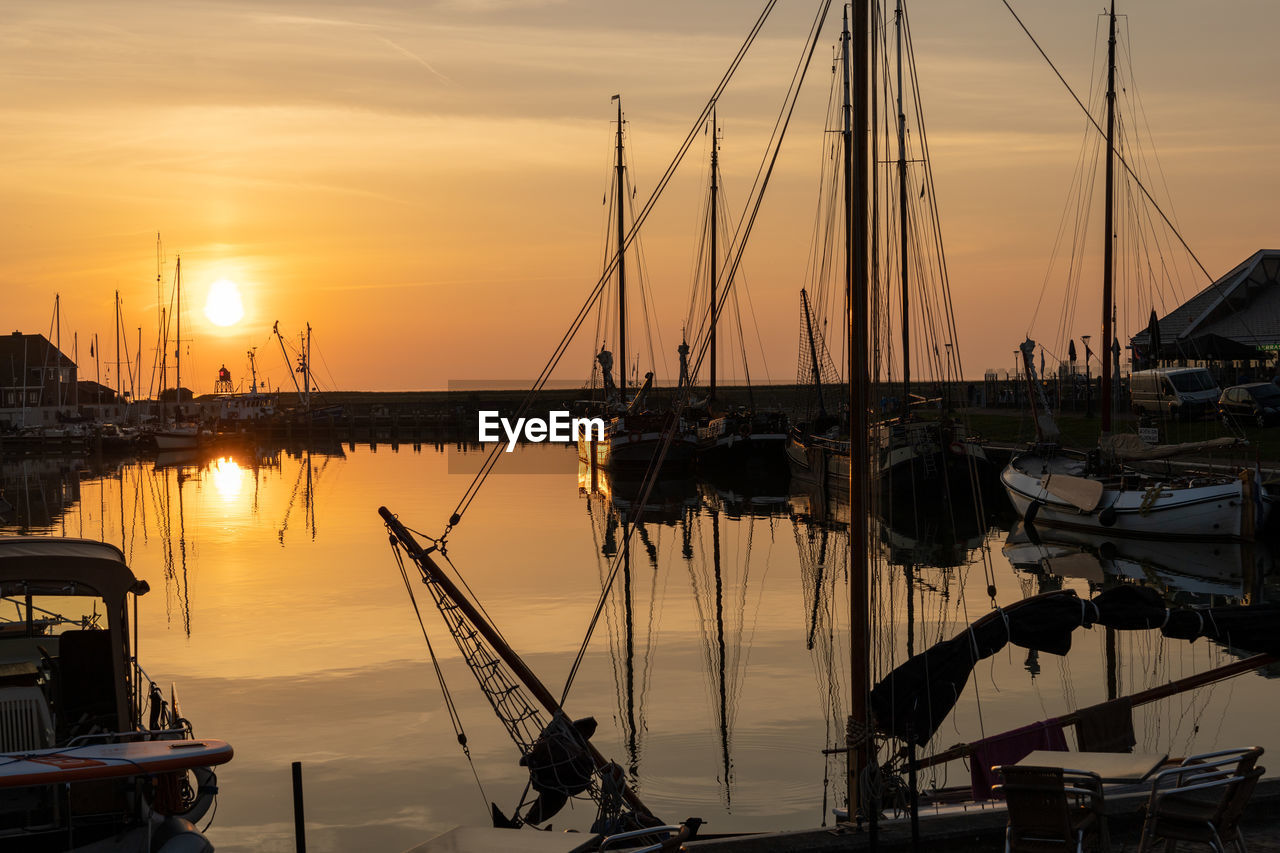 Sailboats in marina at sunset