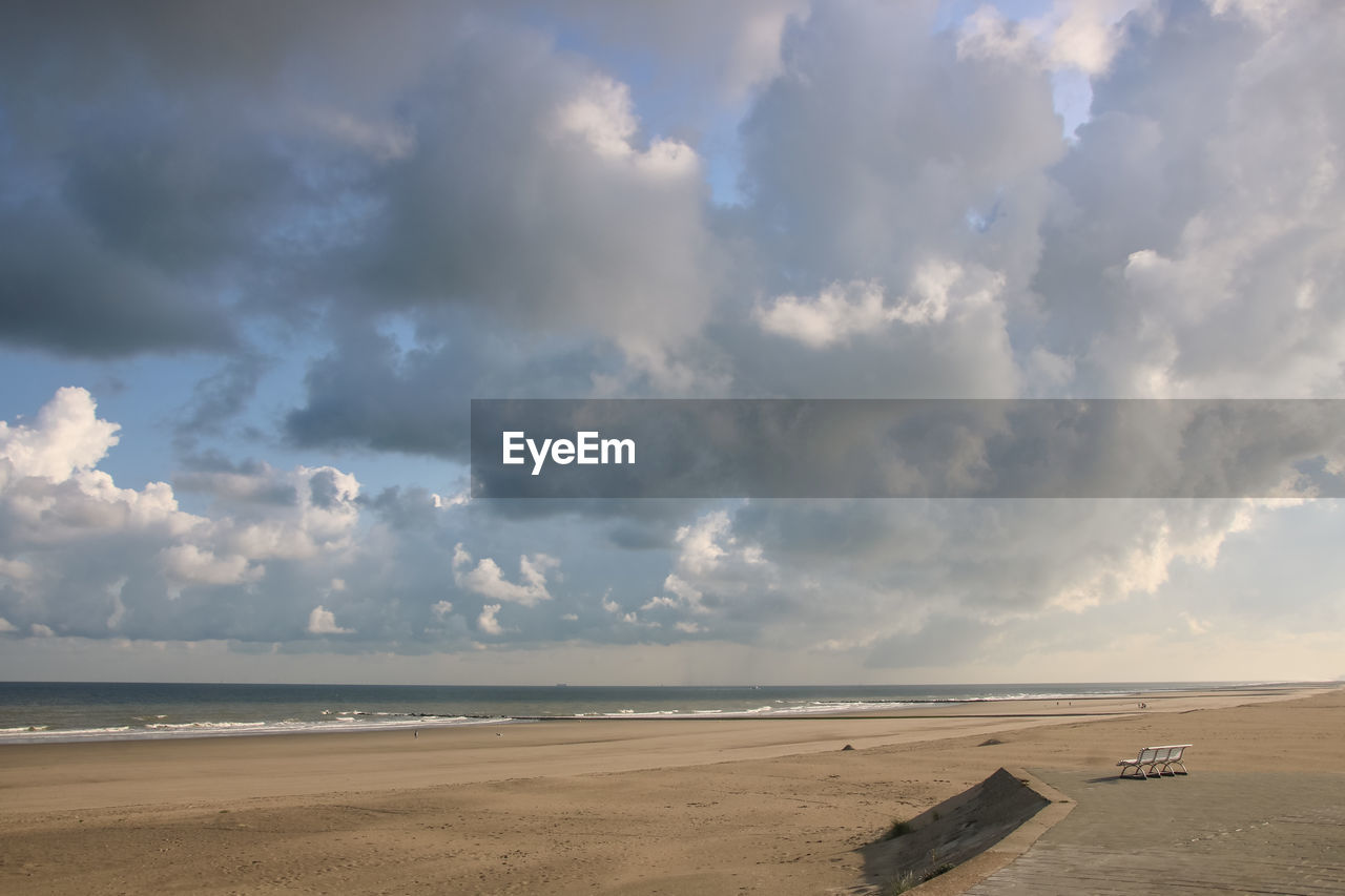 SCENIC VIEW OF BEACH AGAINST CLOUDY SKY