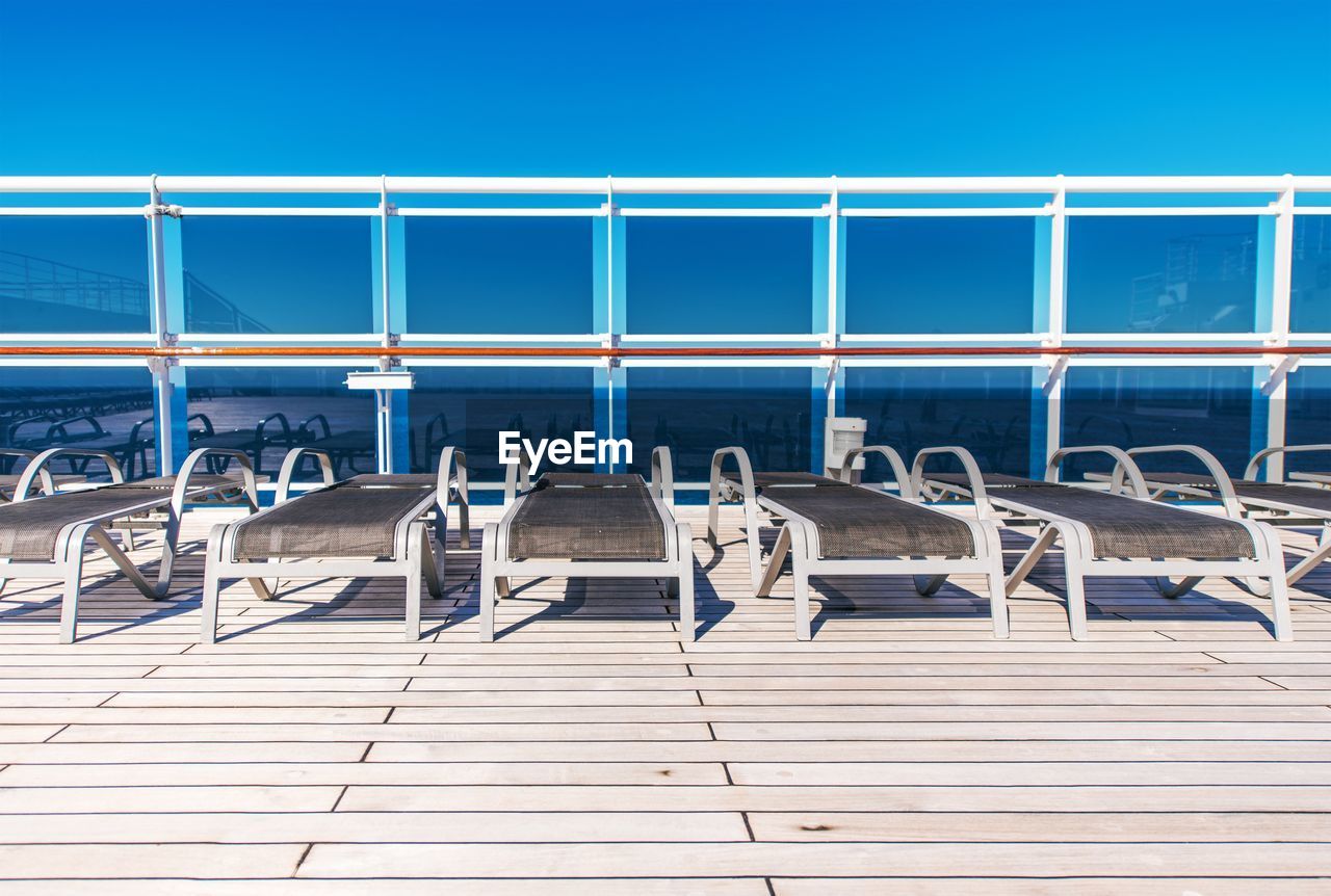 CHAIRS AGAINST BLUE SKY WITH SEA IN BACKGROUND