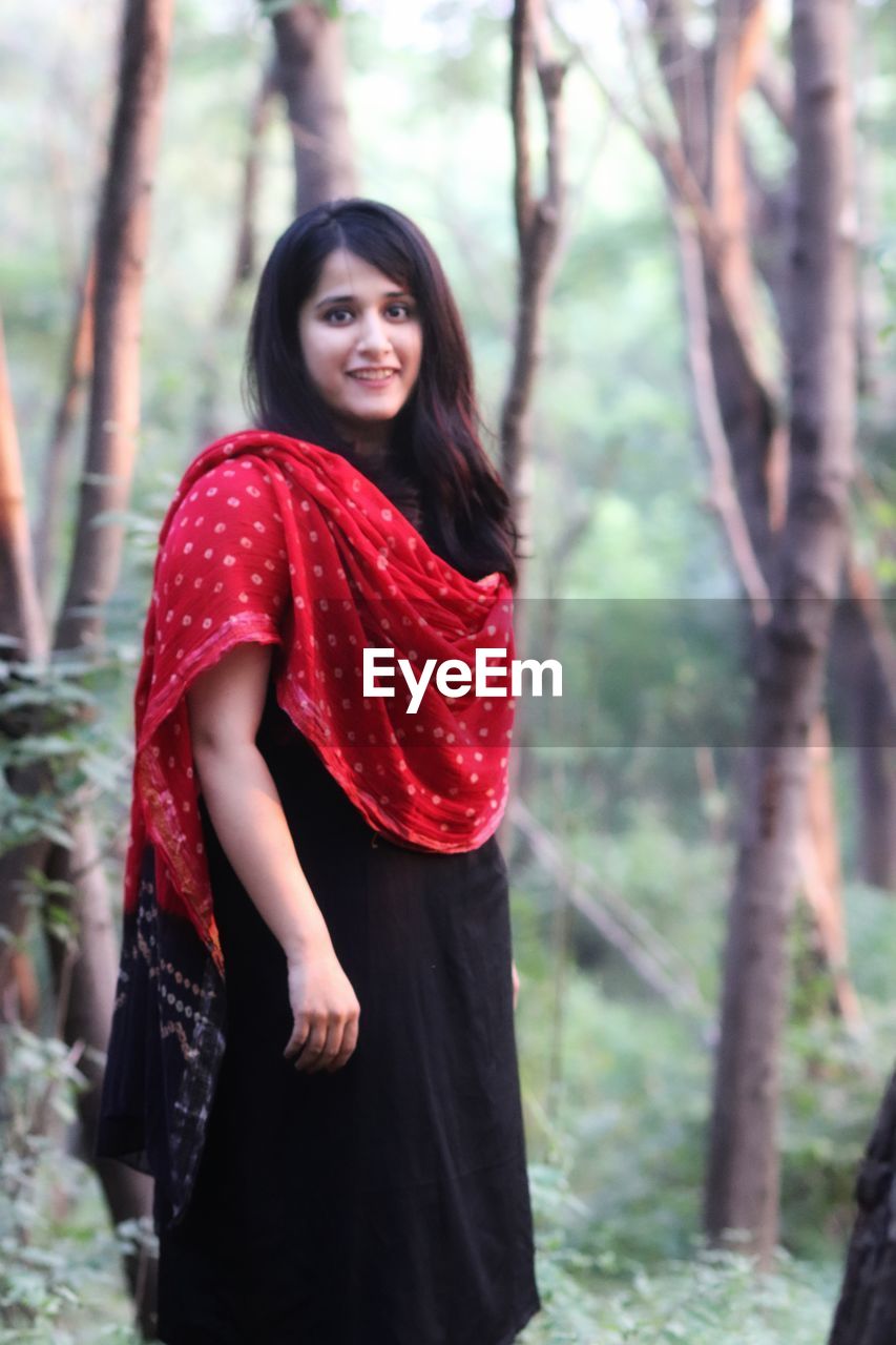 Portrait of smiling young woman standing outdoors