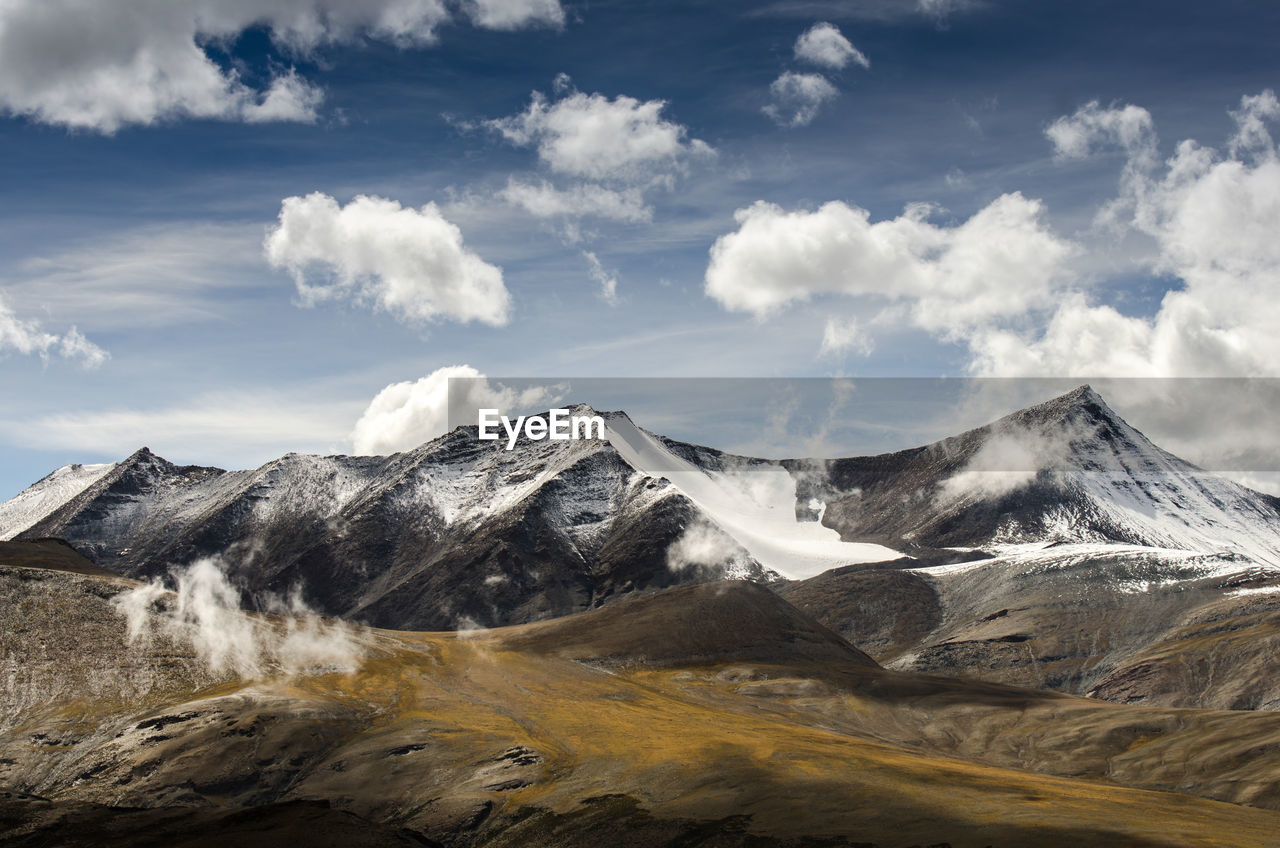 Scenic view of mountain range against cloudy sky 