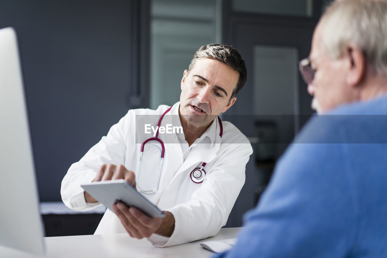 Doctor showing tablet to patient in medical practice