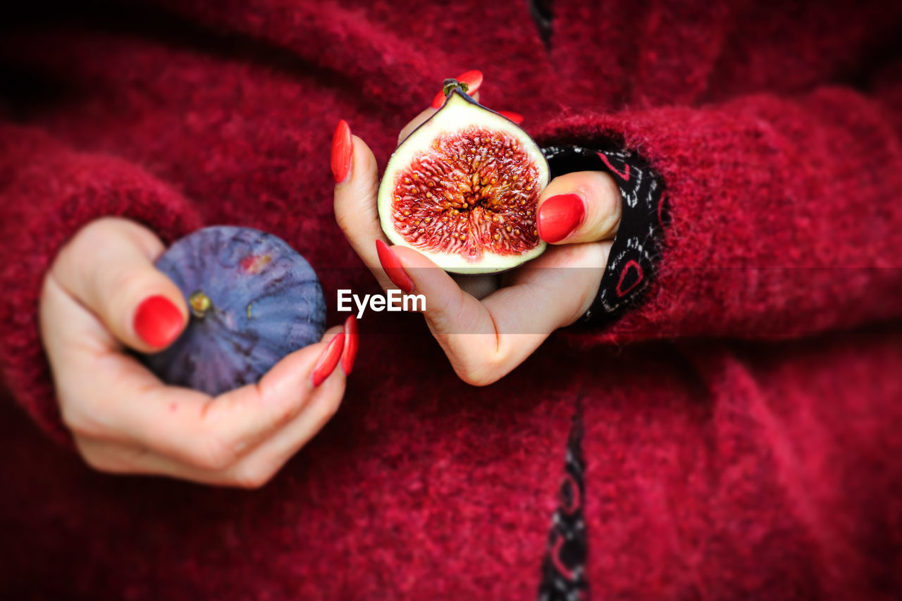 Midsection of woman holding fig