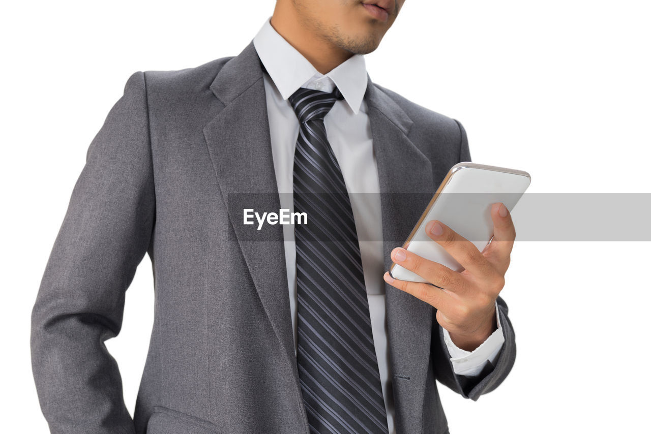 Midsection of businessman using phone against white background