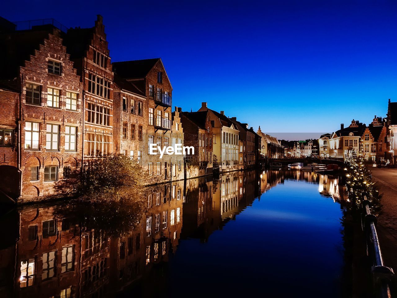 Reflection of buildings in city at dusk