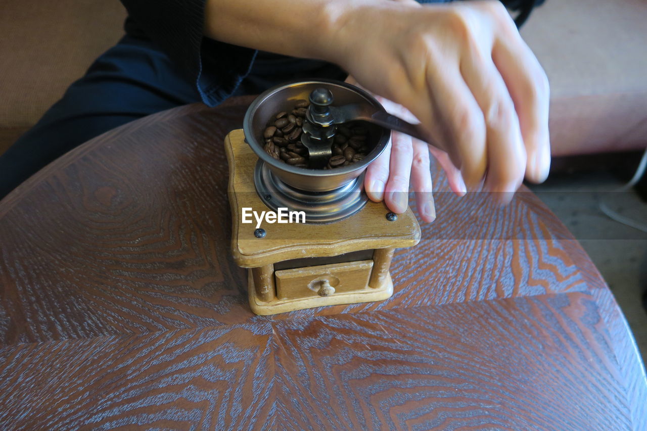 High angle view of person grinding coffee on table