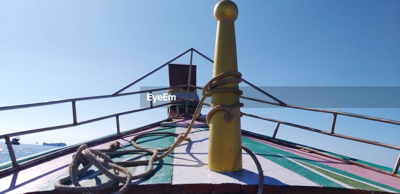 LOW ANGLE VIEW OF RAILING AGAINST BLUE SKY