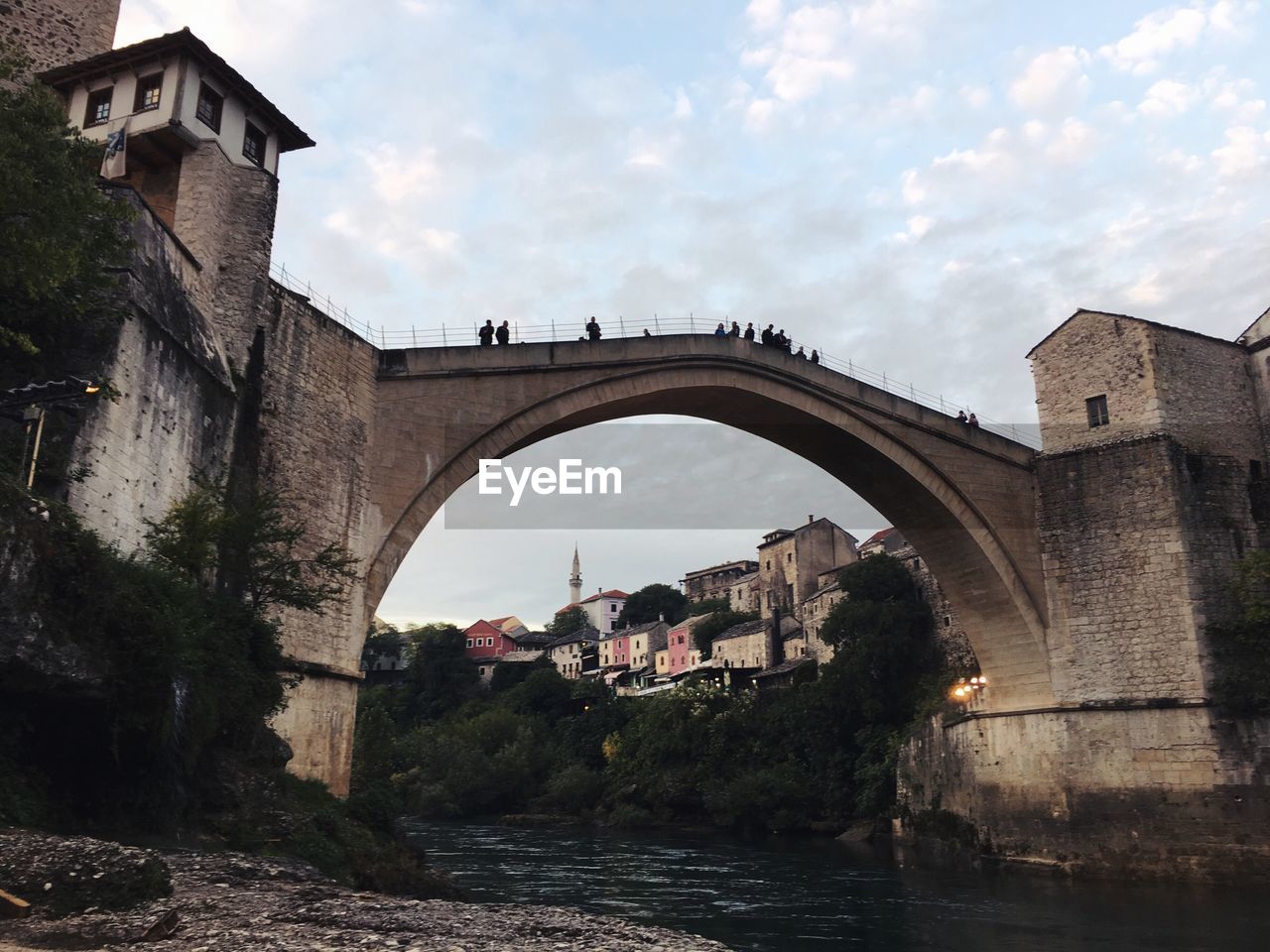 Arch bridge over river against sky