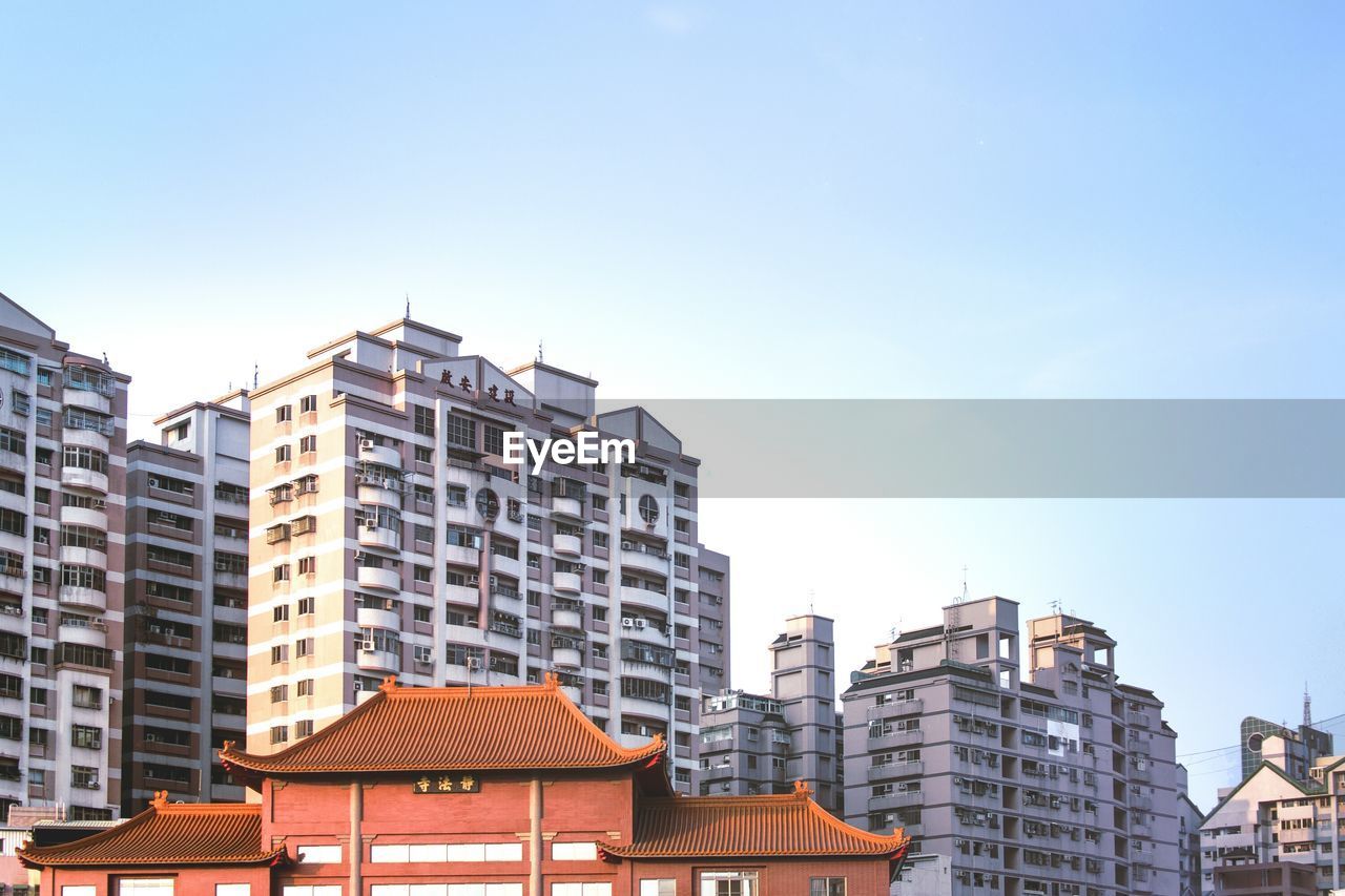 Low angle view of buildings against clear blue sky