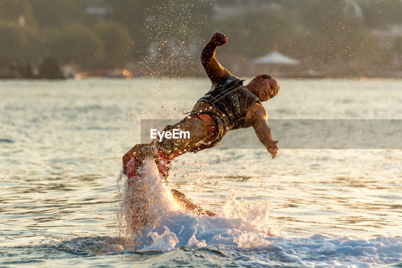 Man flyboarding in sea