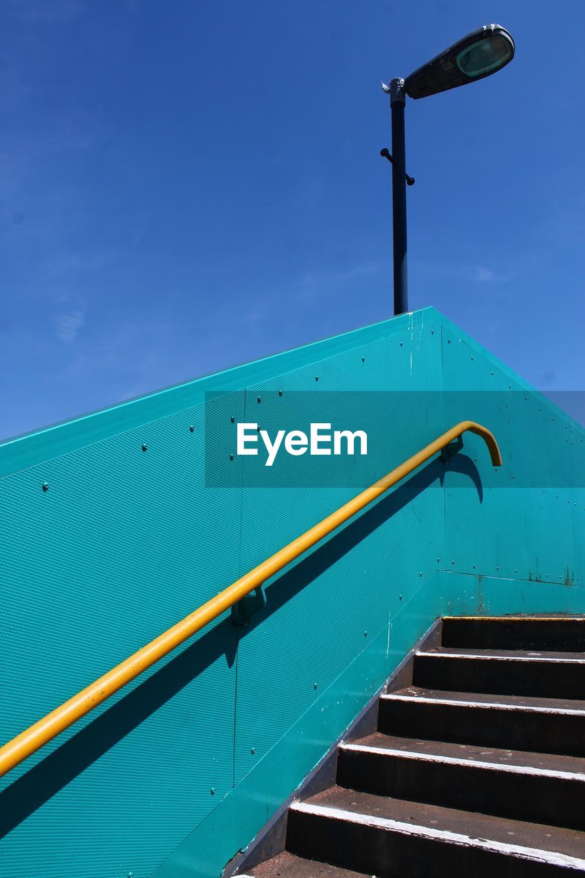 Low angle view of stairs against blue sky