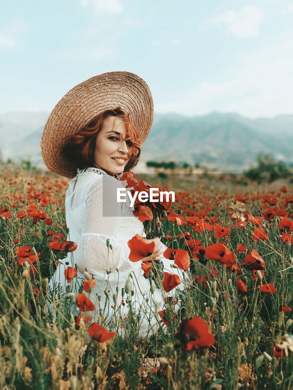 Young woman in ref flower field