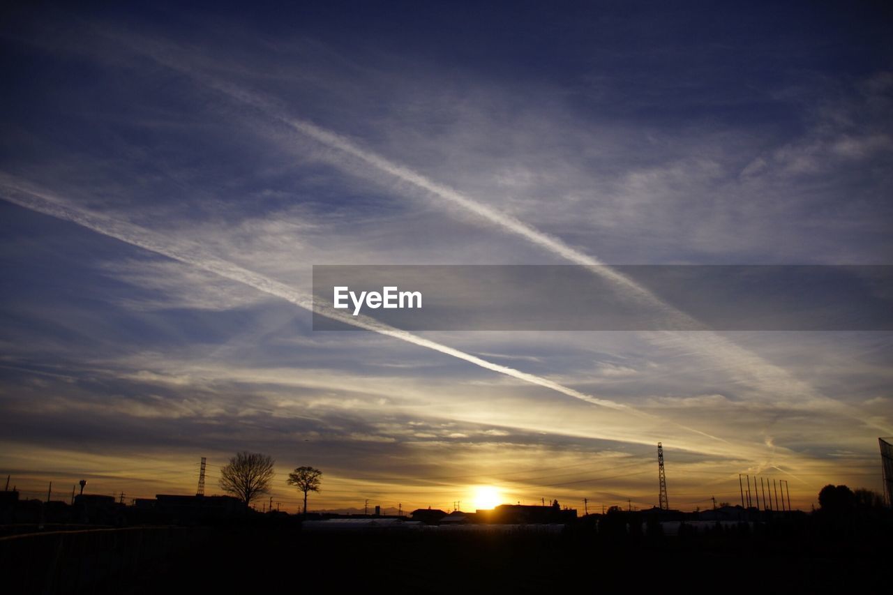 Scenic view of silhouette field against sky at sunset