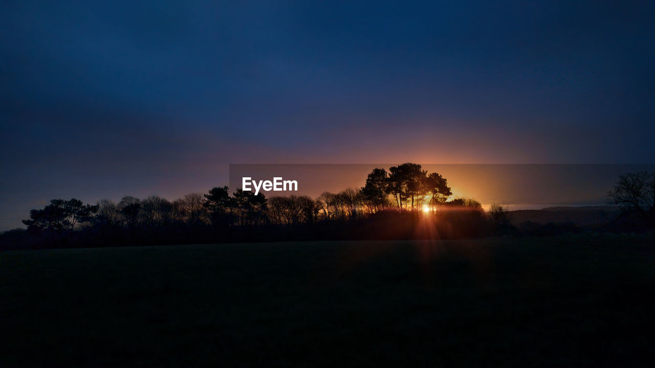 SILHOUETTE TREES ON FIELD AGAINST SKY