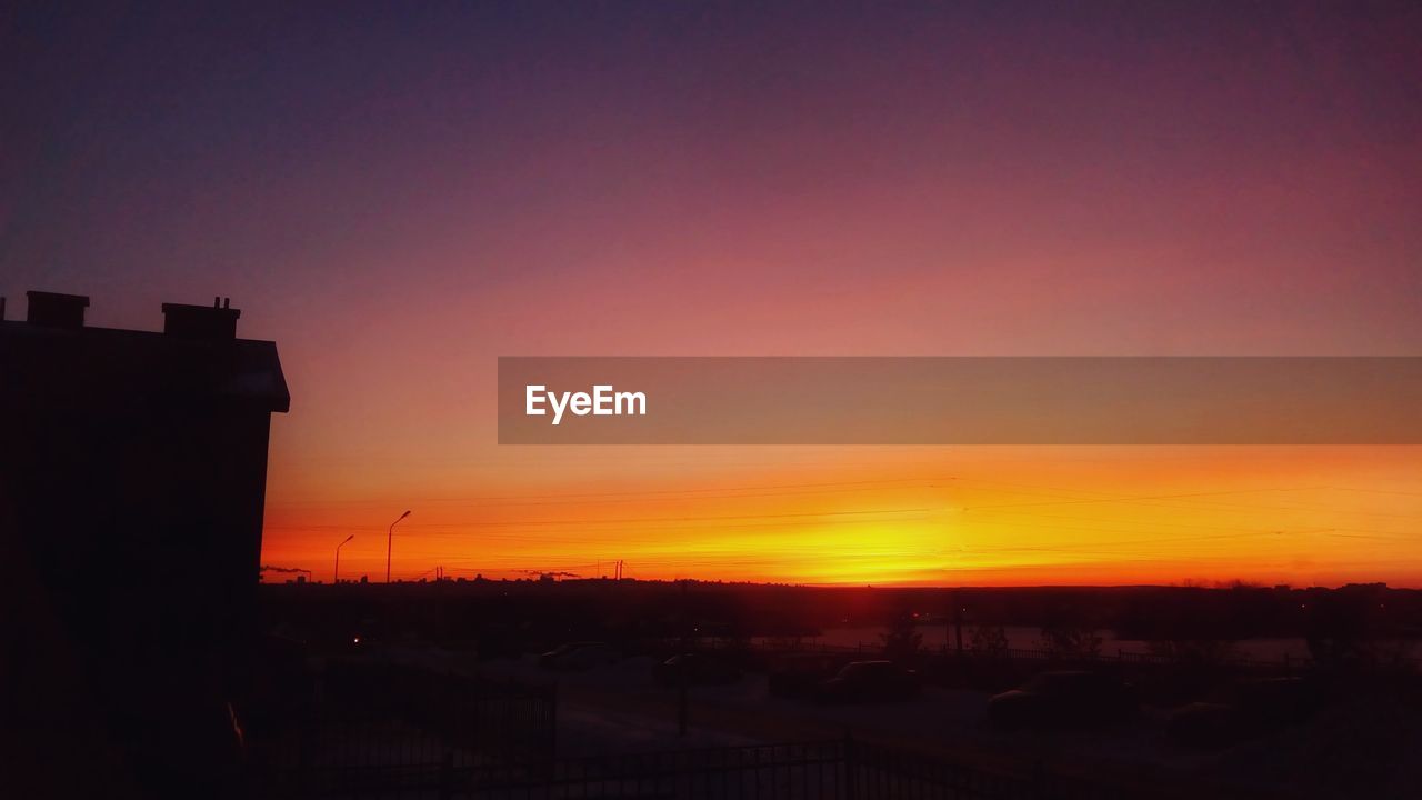 Silhouette city against sky during sunset