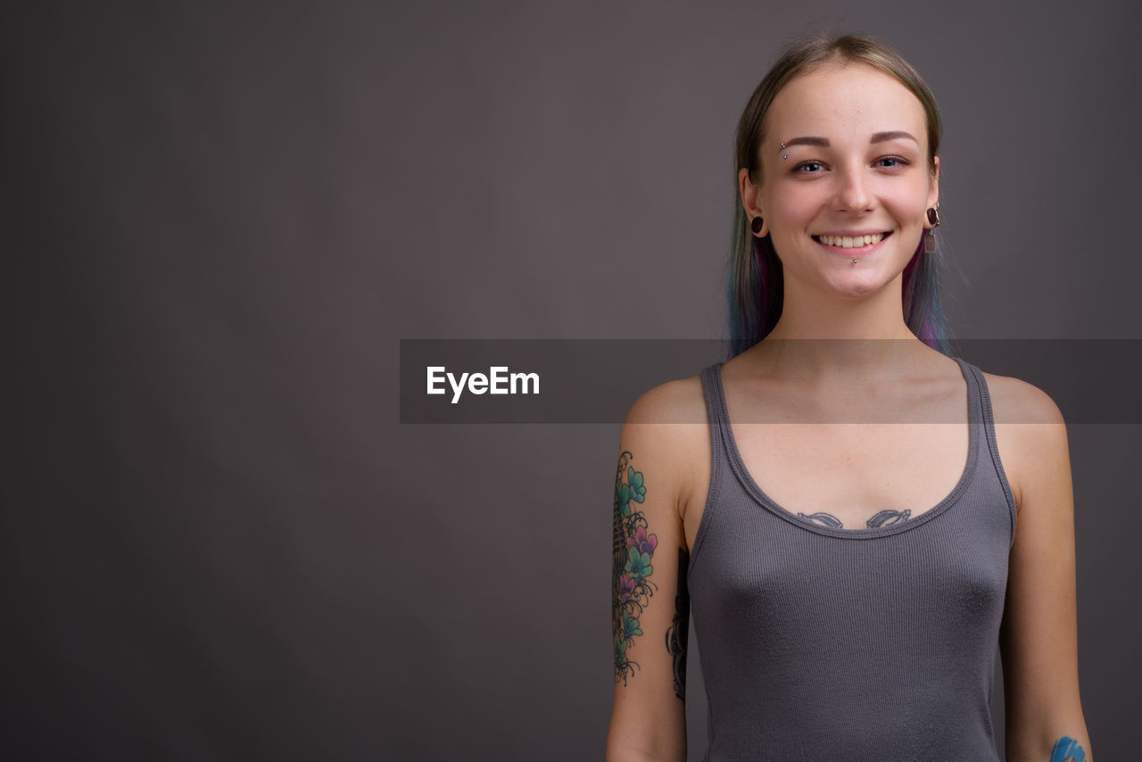 Portrait of a smiling young woman against black background