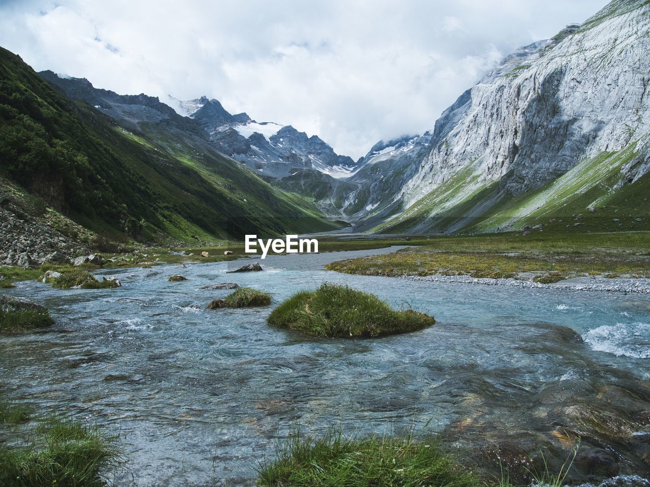 Scenic view of river amidst mountains against sky