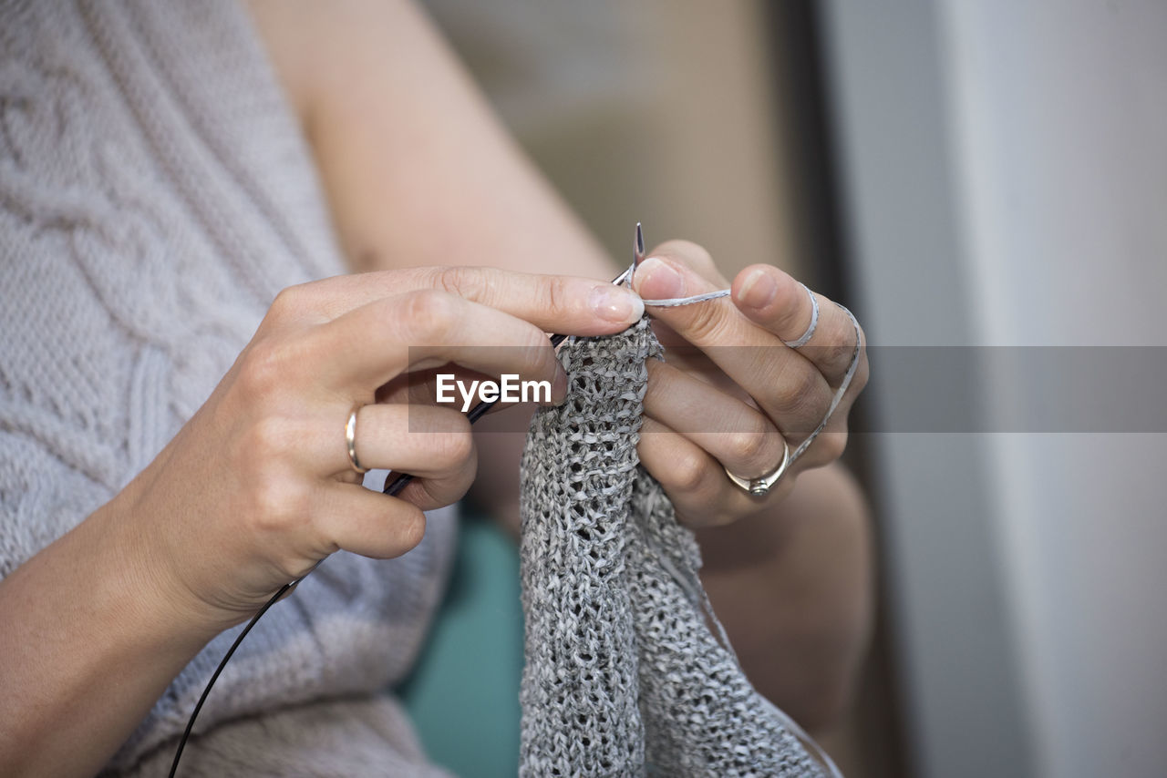 A woman knitting as part of her work in the household