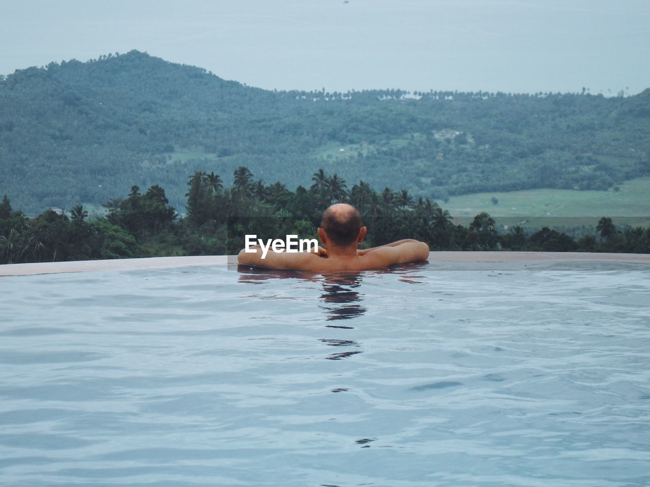 Full length of shirtless man swimming in pool