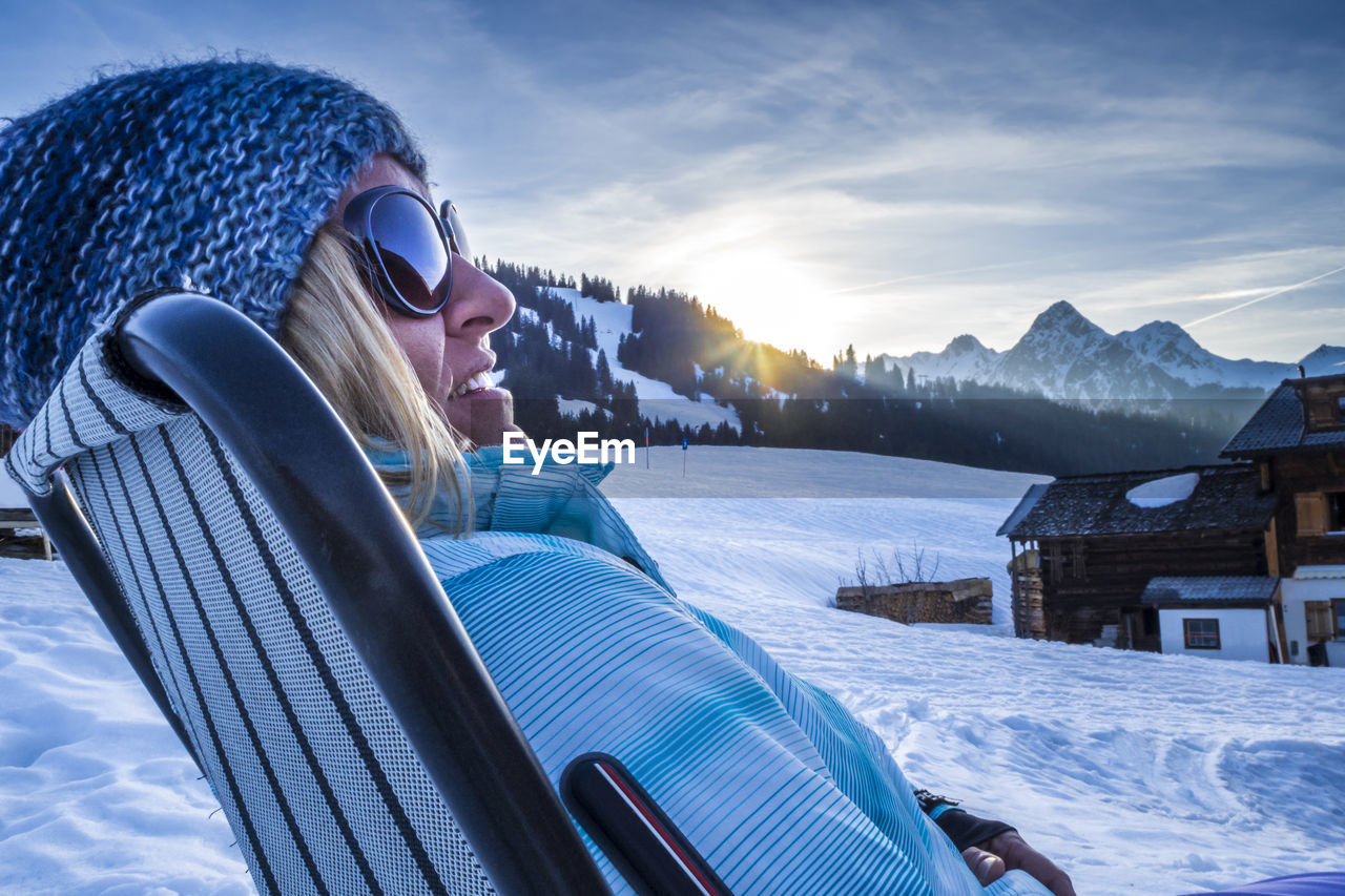 Woman relaxing on snow covered landscape