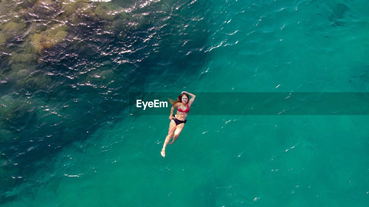 High angle view of bikini woman swimming in sea