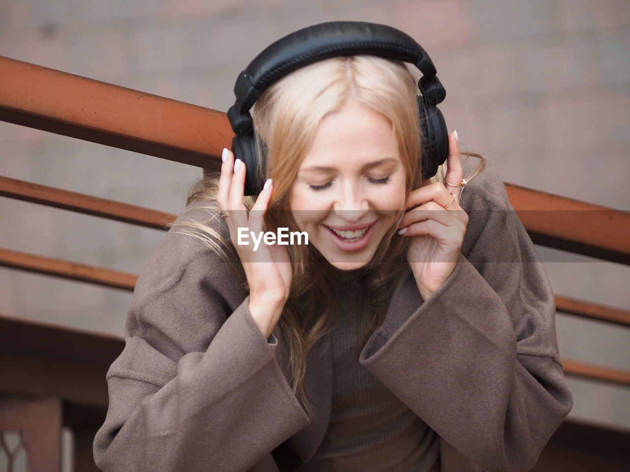Cheerful woman listening music on headphones