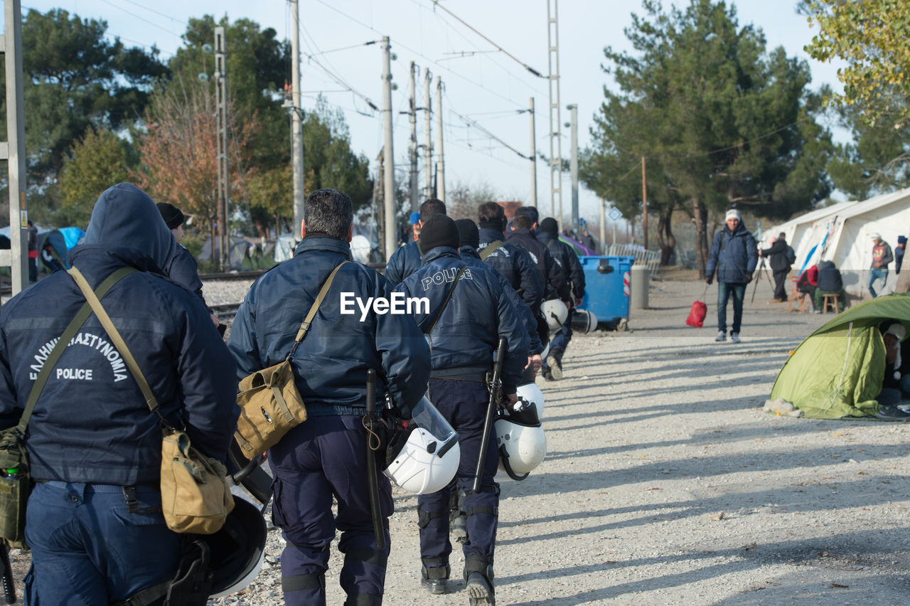 Police force walking on footpath at refugee camp