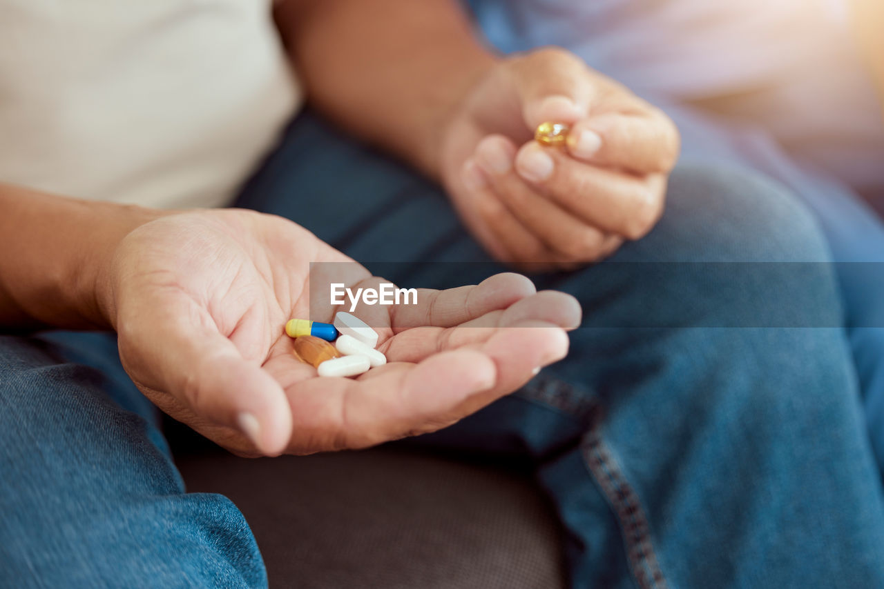 low section of woman holding pills