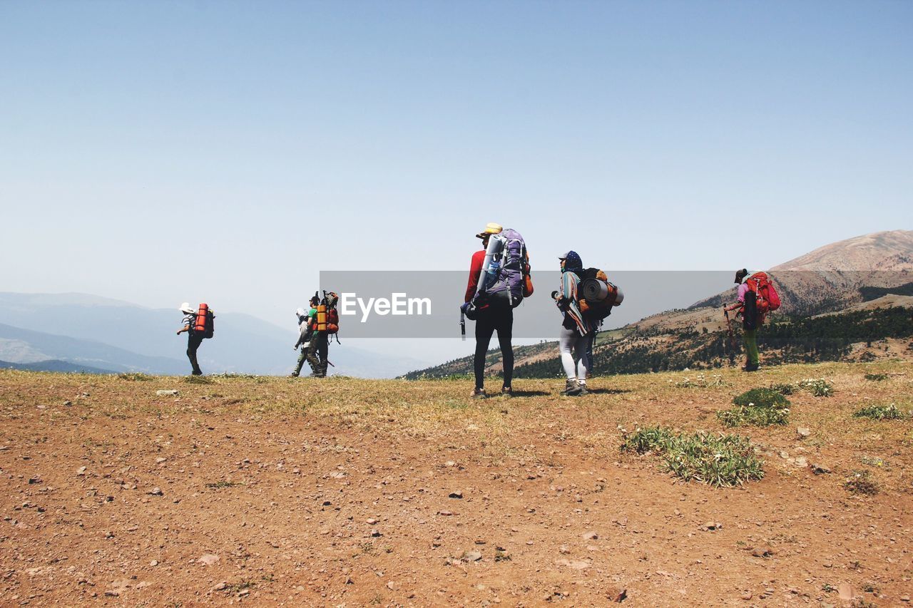 Rear view of people hiking on mountain