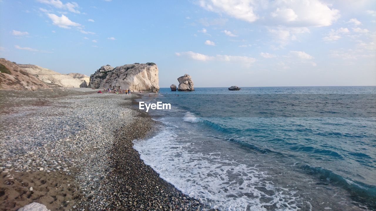 People enjoying a sunny day at aphrodites rock beach in cyprus