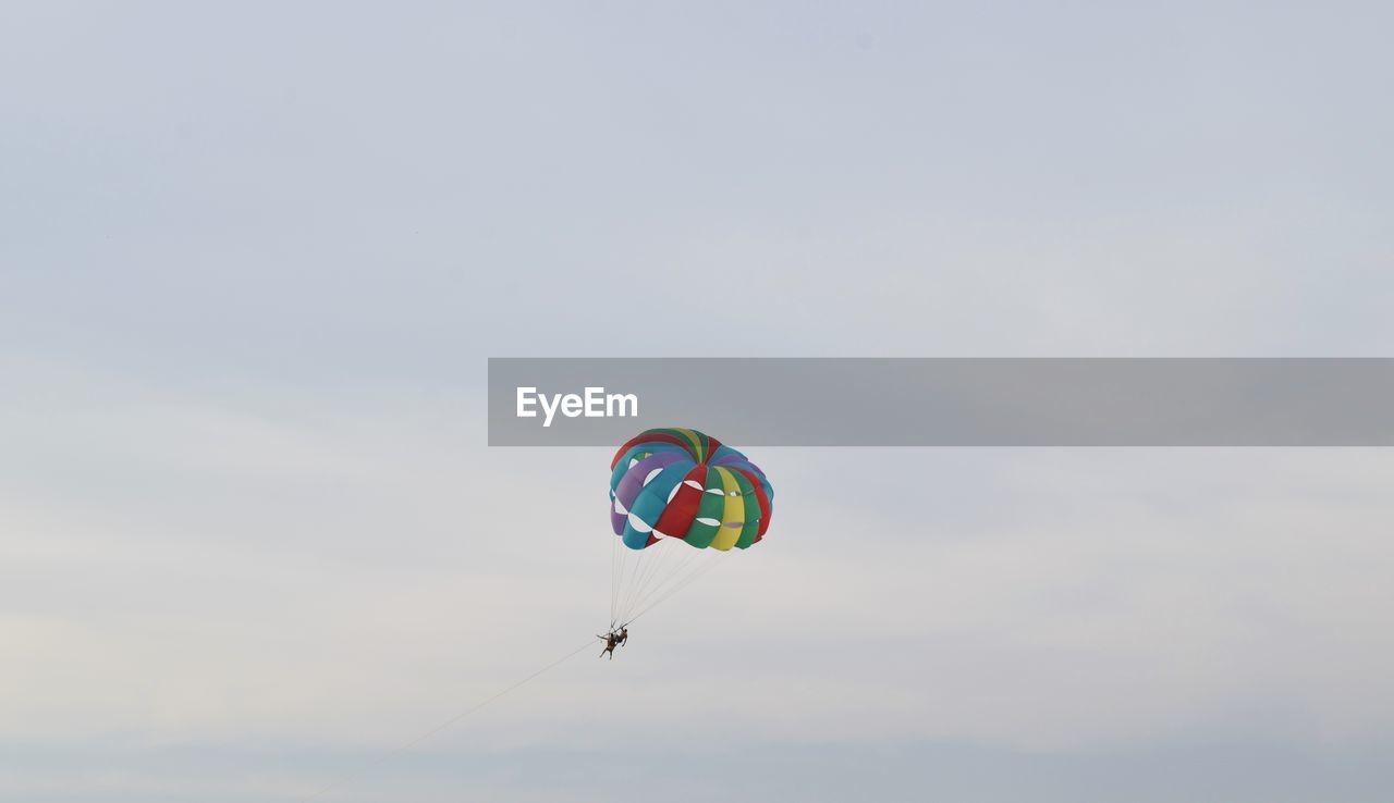 LOW ANGLE VIEW OF PERSON PARAGLIDING